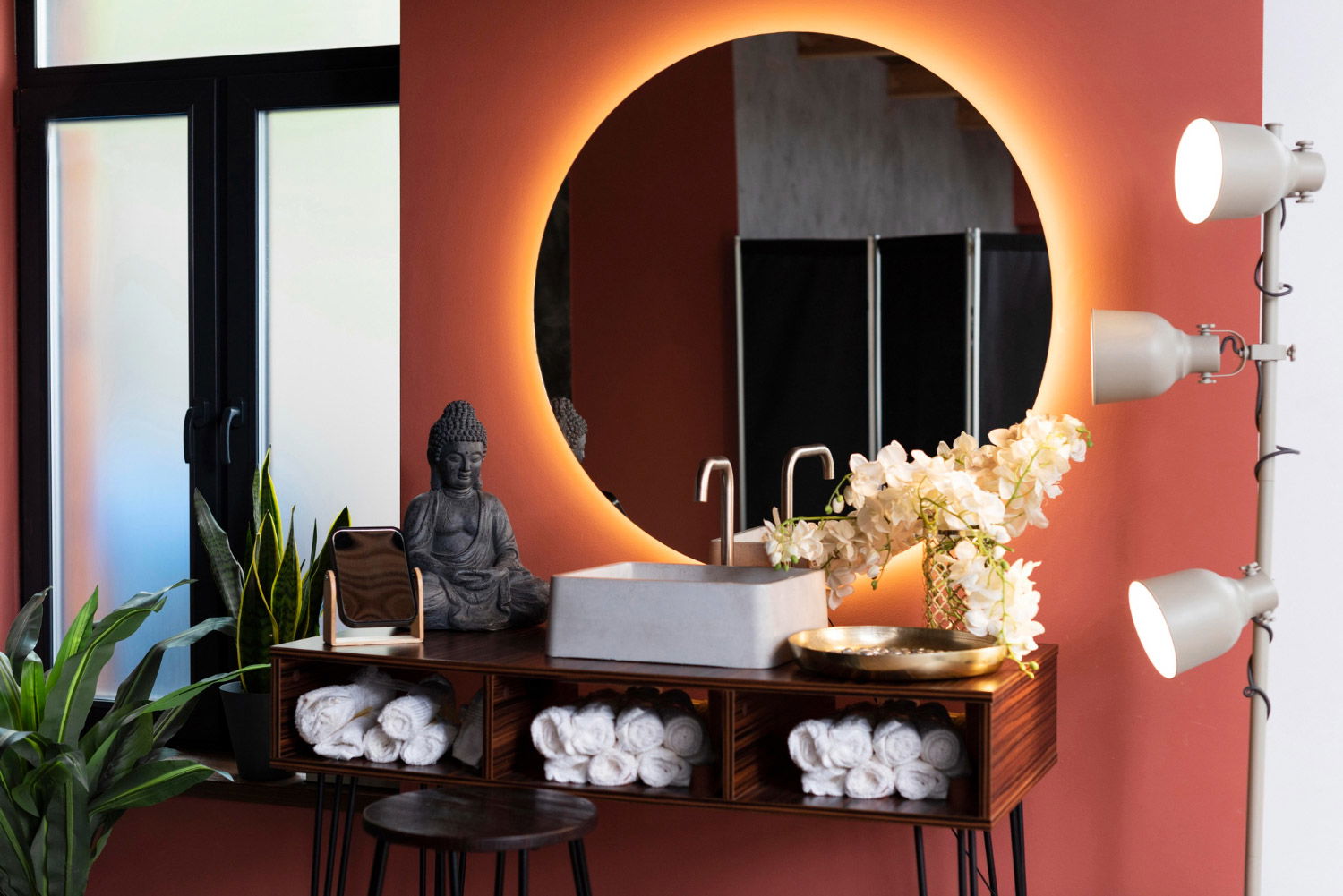 A bathroom with a round mirror and a lamp.