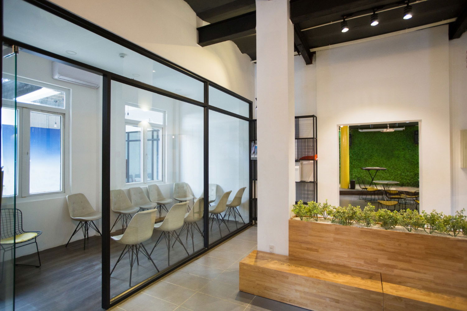 A meeting room with a glass wall and chairs.